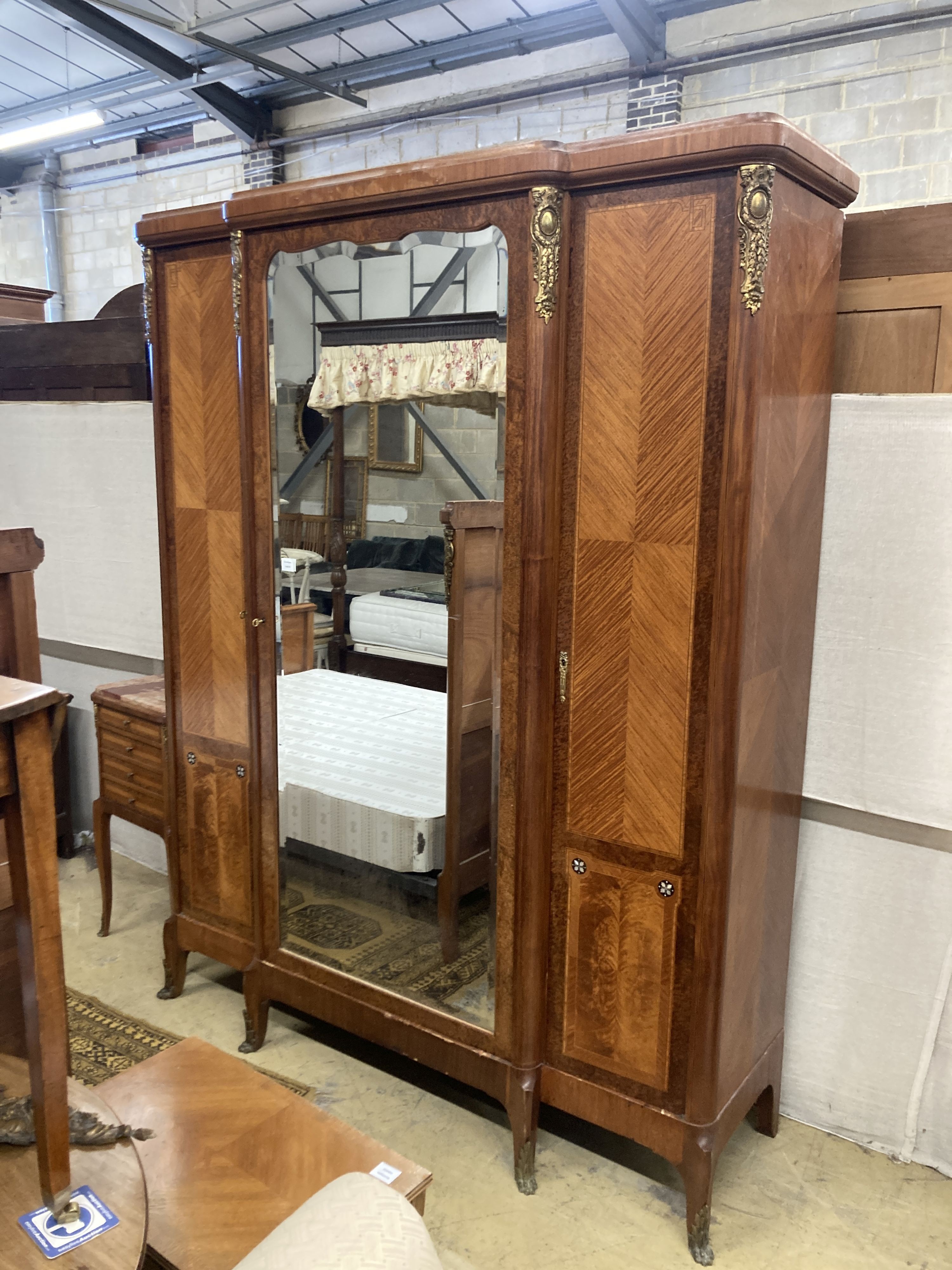 A Louis XVI style three piece gilt metal mounted kingwood bedroom suite, consisting:- an armoire, a bedstead and a marble topped bedside cupboard, armoire W.174cm D.55cm H.224cm